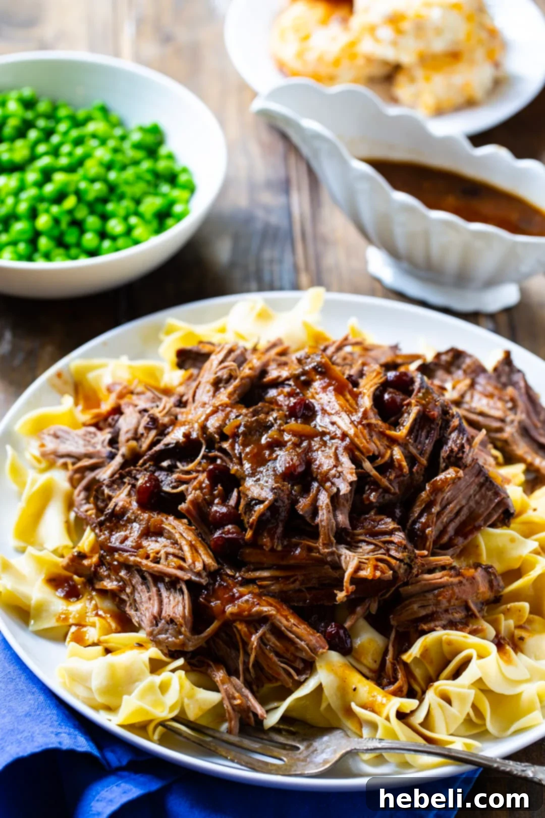 Pot Roast over buttered noodles and a bowl of peas.