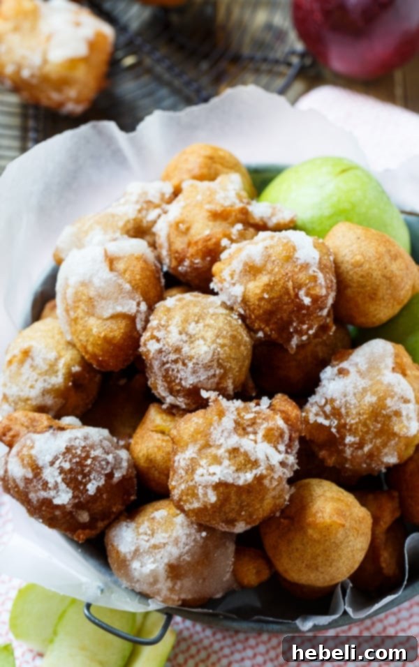 Spiced Apple Delight Puffs 4 A close-up of a perfectly fried and glazed Apple Fritter, showcasing its crispy exterior and the sweet, spirited coating, resting on a serving plate.