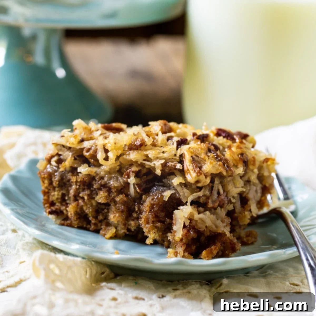 Grandma's Oatmeal Cake 2 A slice of Old-Fashioned Oatmeal Cake on a plate, with a jug of milk in the background, inviting a comforting dessert experience.