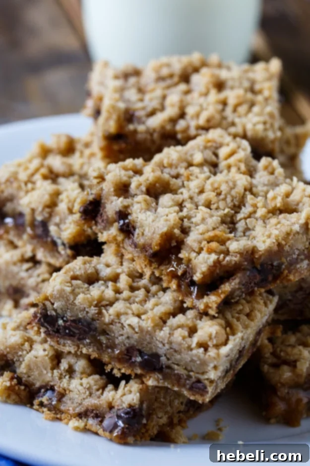 Close-up of Oatmeal Carmelitas baking, with melted chocolate chips and caramel sauce peeking through the oatmeal topping.