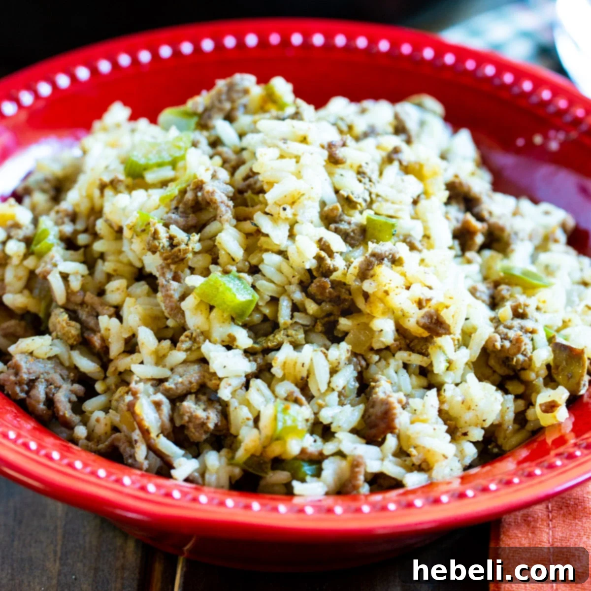 A steaming bowl of freshly made Cajun Dirty Rice, garnished and ready to be served, showcasing its rich, deep color.
