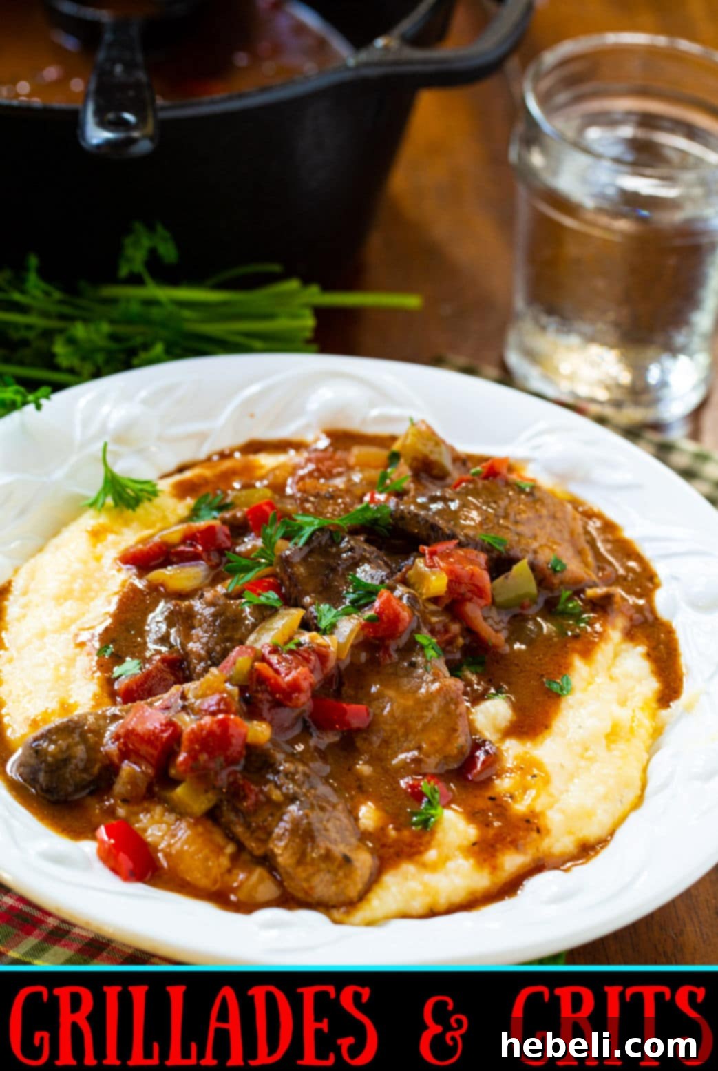A close-up shot of Grillades and Grits in a pasta bowl, highlighting the creamy grits and tender, saucy beef.