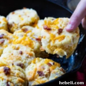 Cheddar Bacon Delights 5 Hand picking up a Bacon Cheddar Biscuit.