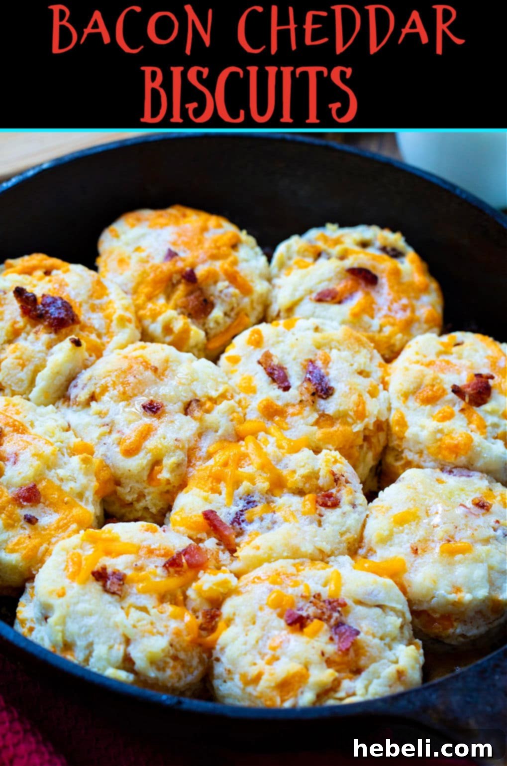 Cheddar Bacon Delights 6 A close-up of two warm Bacon Cheddar Biscuits in a basket, with visible pieces of crispy bacon and melted cheddar cheese.