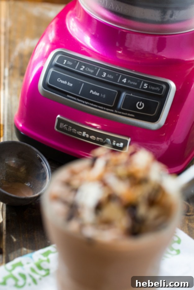 Close-up of a German Chocolate Milkshake in a tall glass, showing its creamy texture and toppings