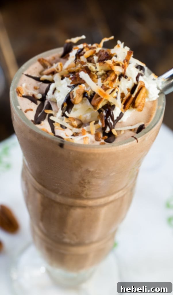 Side view of a German Chocolate Milkshake, showcasing layers of chocolate, coconut, and pecans