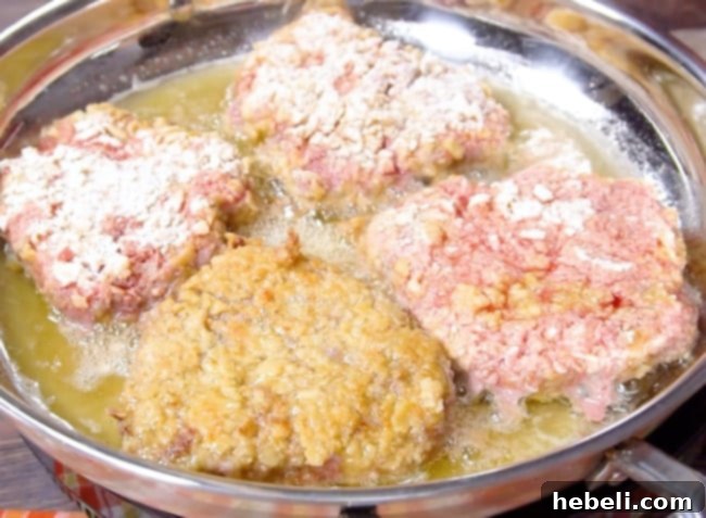 Chicken Fried Steak sizzling in hot oil in a cast iron pan