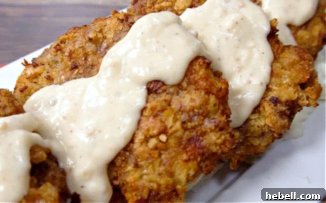 Rich white gravy being poured over a piece of crispy Chicken Fried Steak