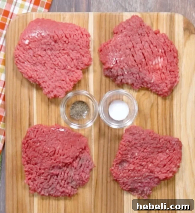Seasoning cubed steak with salt and pepper on a cutting board