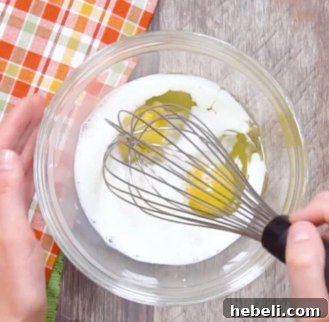 Eggs and milk being whisked together in a shallow bowl