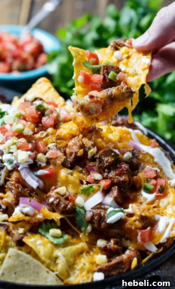 Ultimate Brisket BBQ Nachos 7 A generous serving of BBQ Brisket Nachos with all the fixings, ready to be enjoyed.