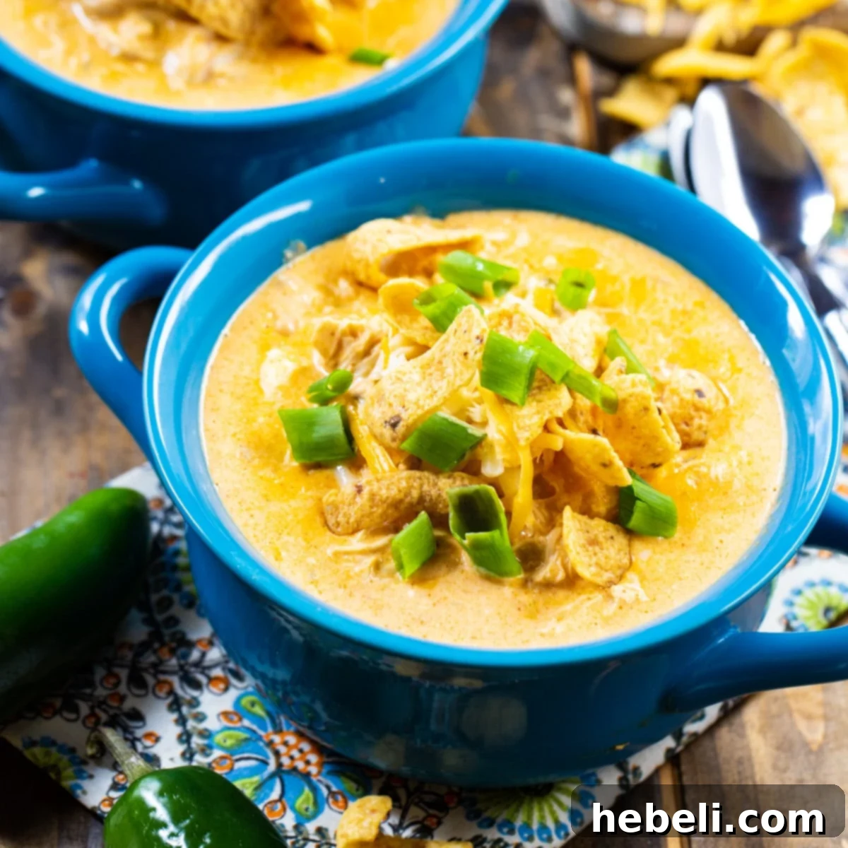 Slow Cooker White Chicken Chili topped with frito chips in a blue bowl.