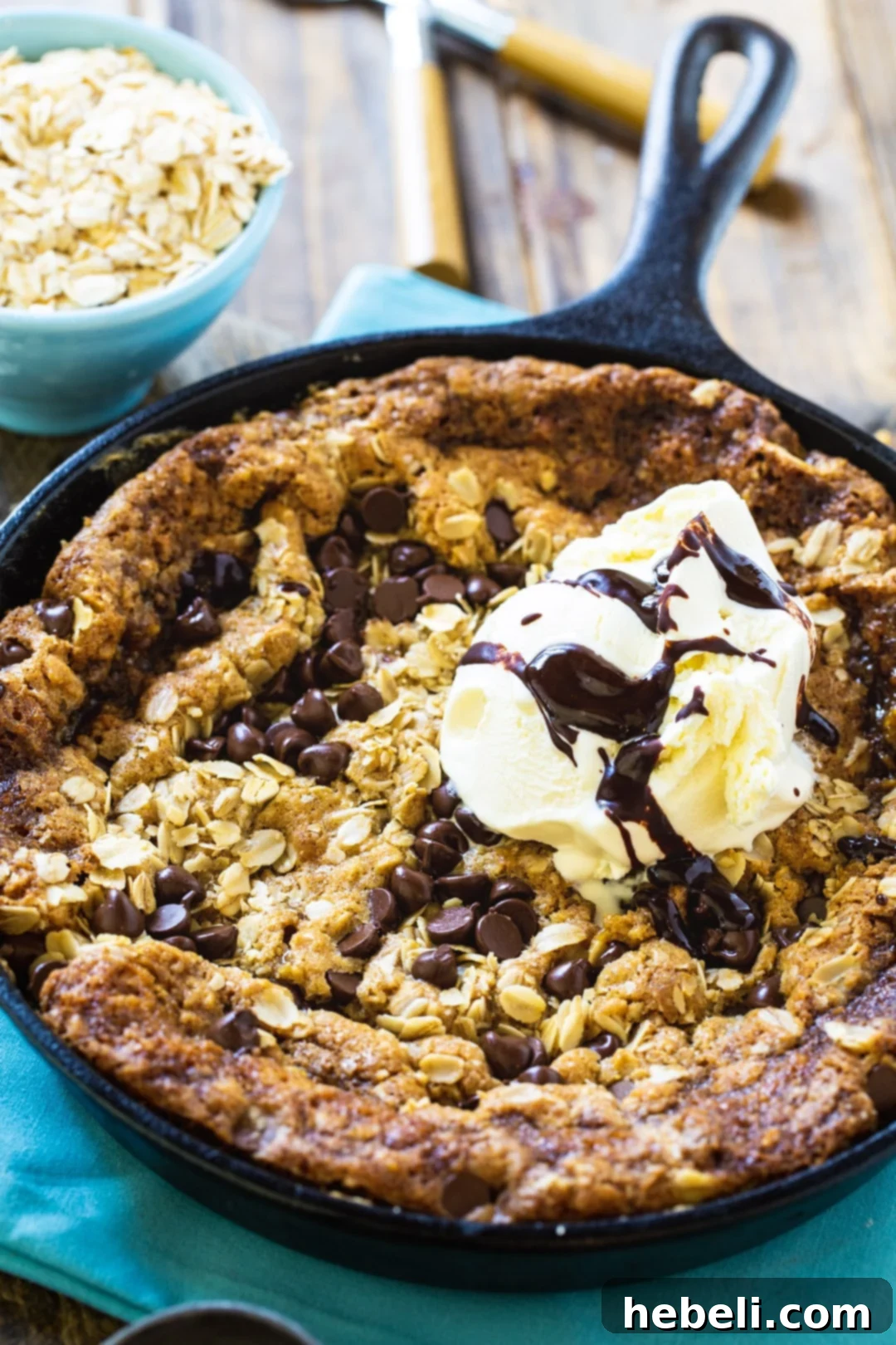 Decadent Skillet Cookie topped generously with scoops of melting vanilla ice cream, ready to be enjoyed.