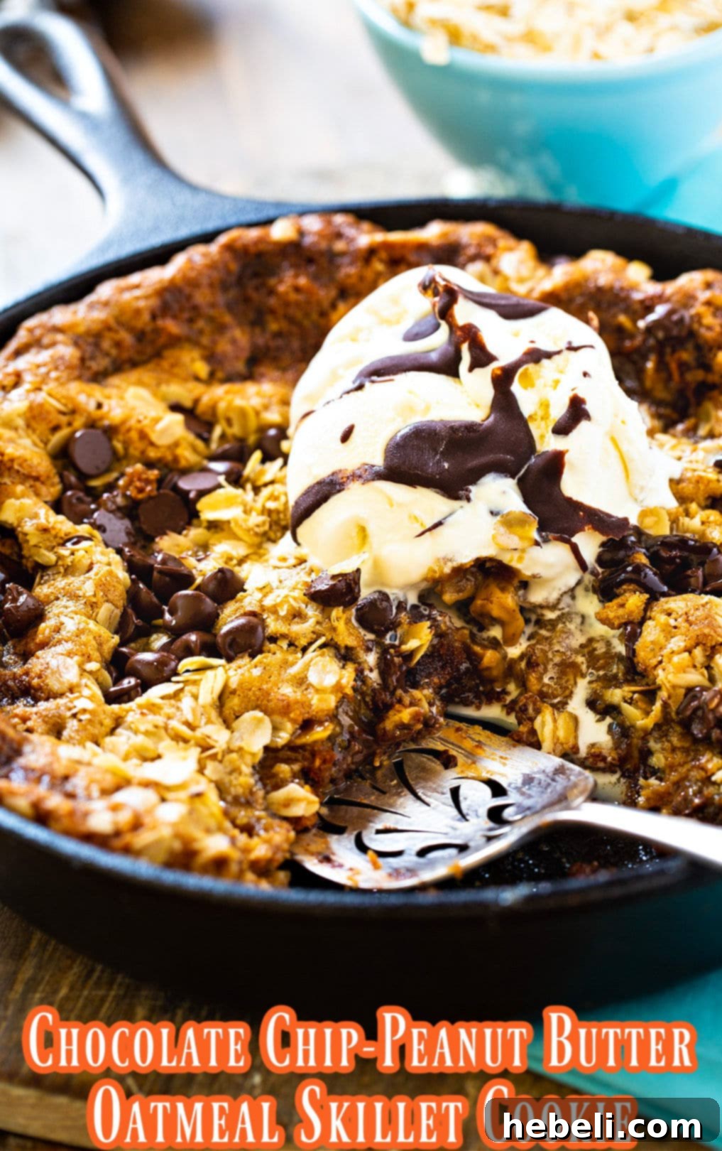 A generous slice of Chocolate Chip-Peanut Butter Oatmeal Skillet Cookie removed from the pan, revealing its gooey center.