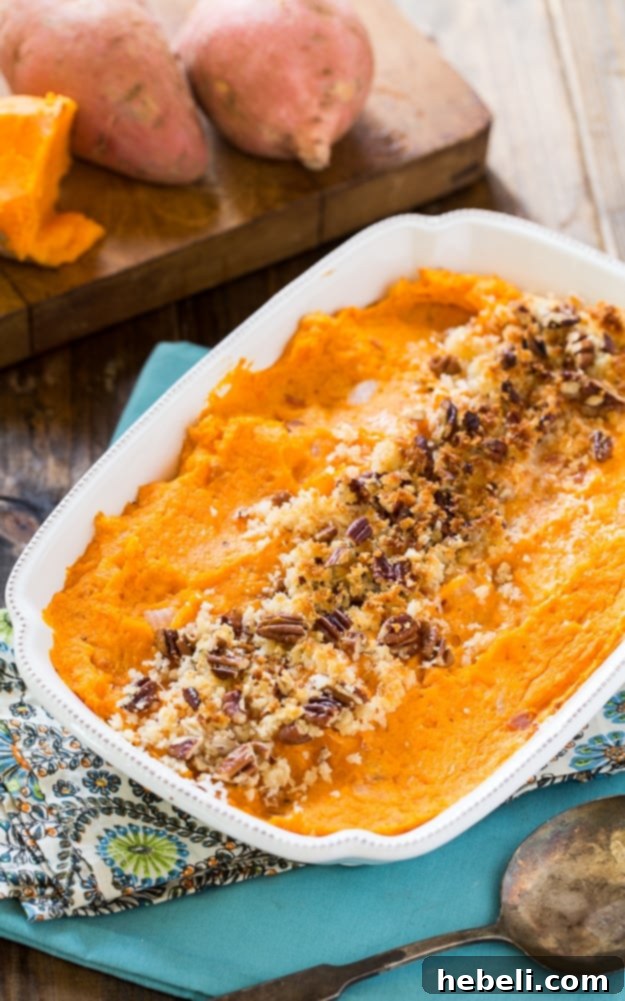 Close-up of Savory Sweet Potato Casserole showcasing crispy bacon, Gruyère cheese, and fresh herbs.