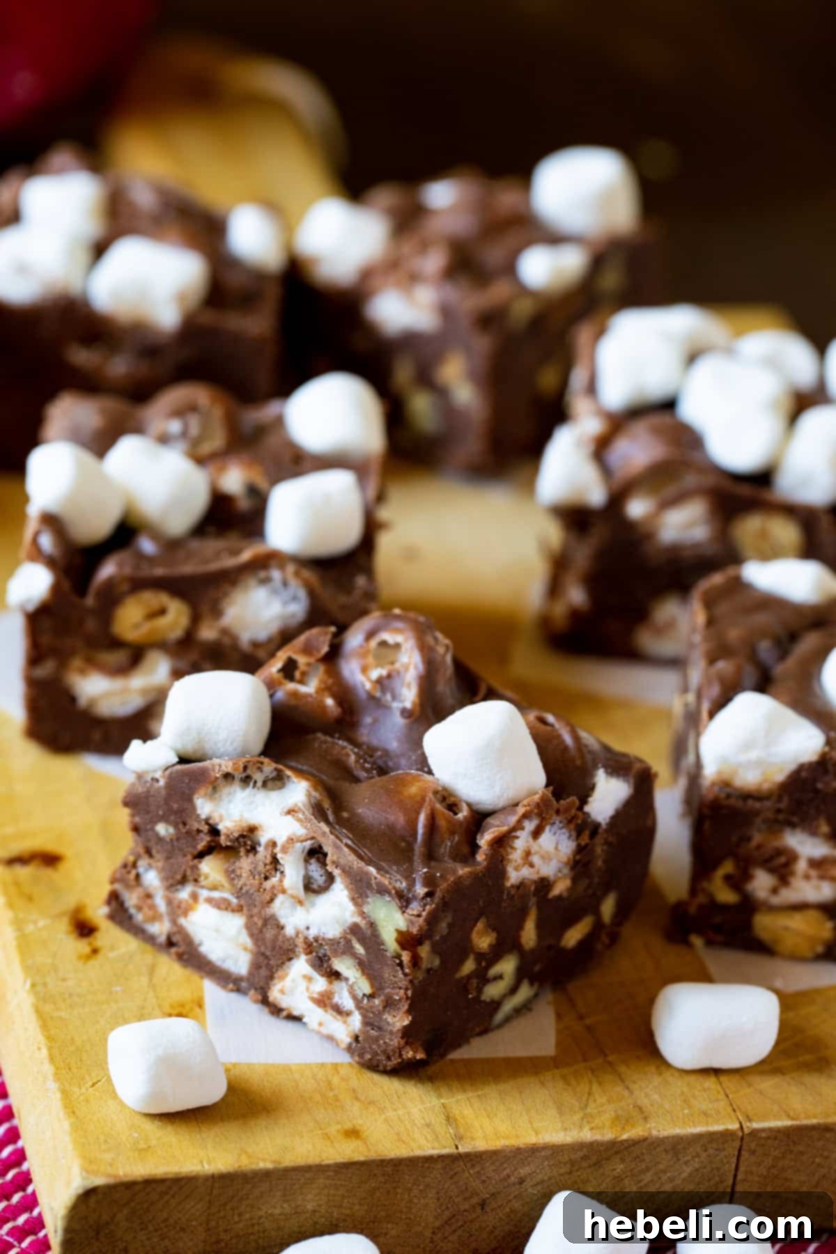 Close-up of squares of Rocky Road Fudge arranged neatly on a cutting board, highlighting the texture and inclusions.