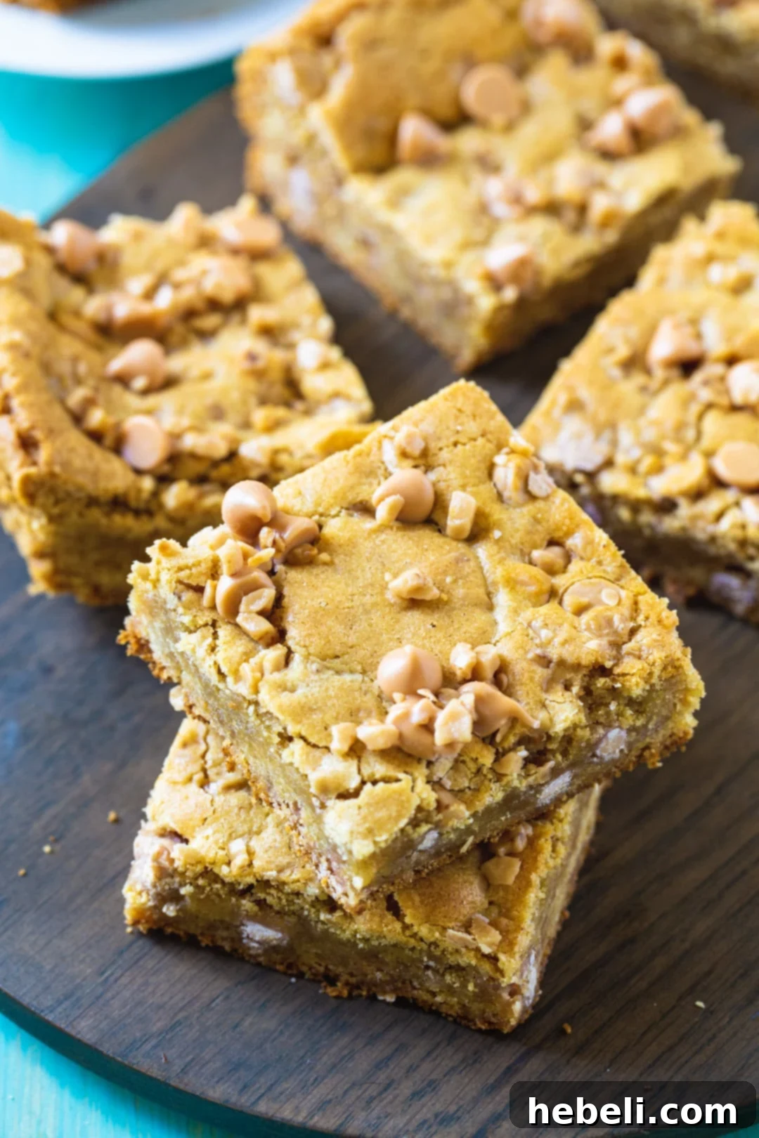 Perfectly cut squares of Butterscotch Toffee Blondies neatly arranged on a wood cutting board, ready to be served and enjoyed.