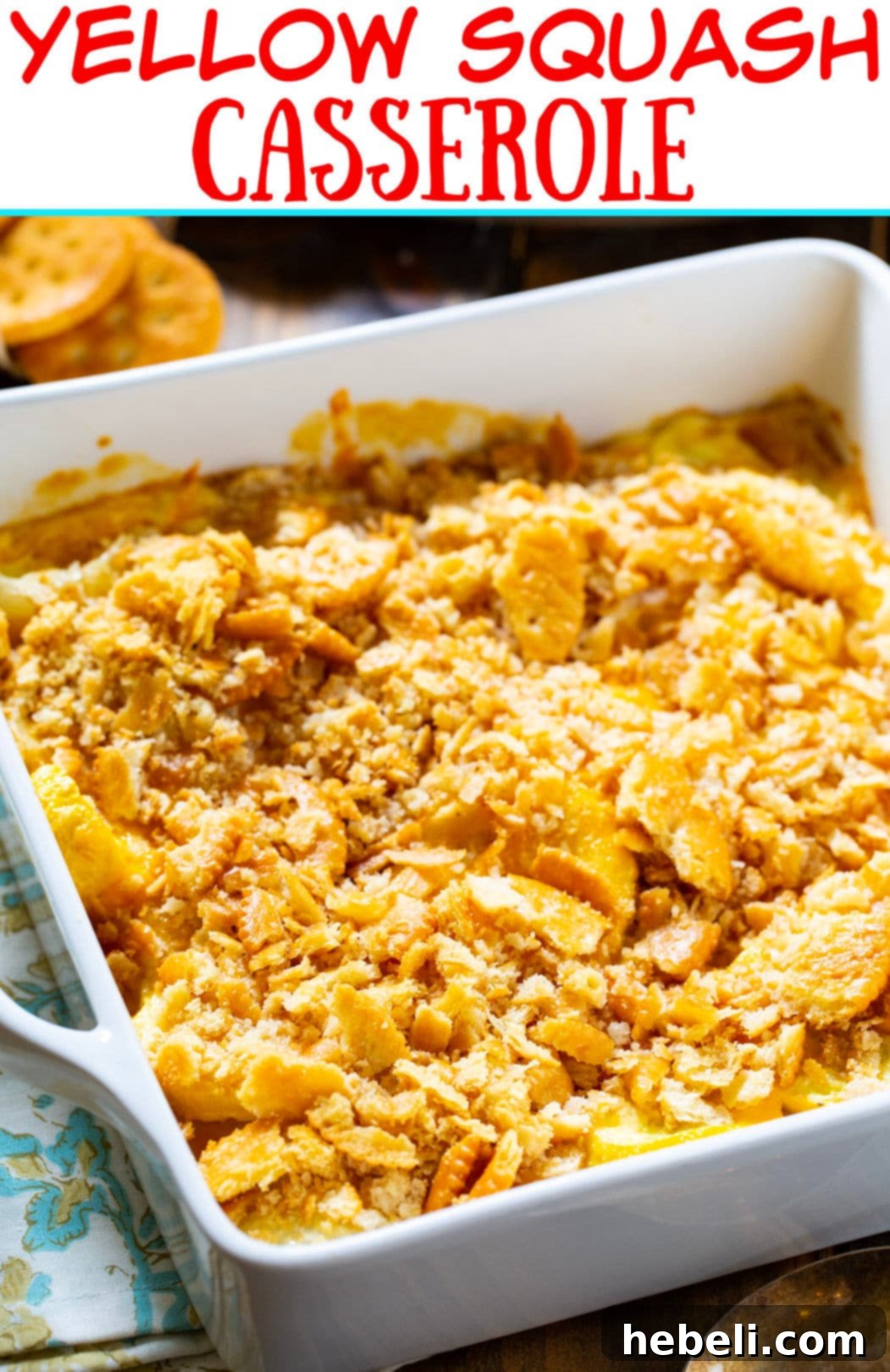A golden brown Yellow Squash Casserole in a square baking dish, garnished with fresh parsley.