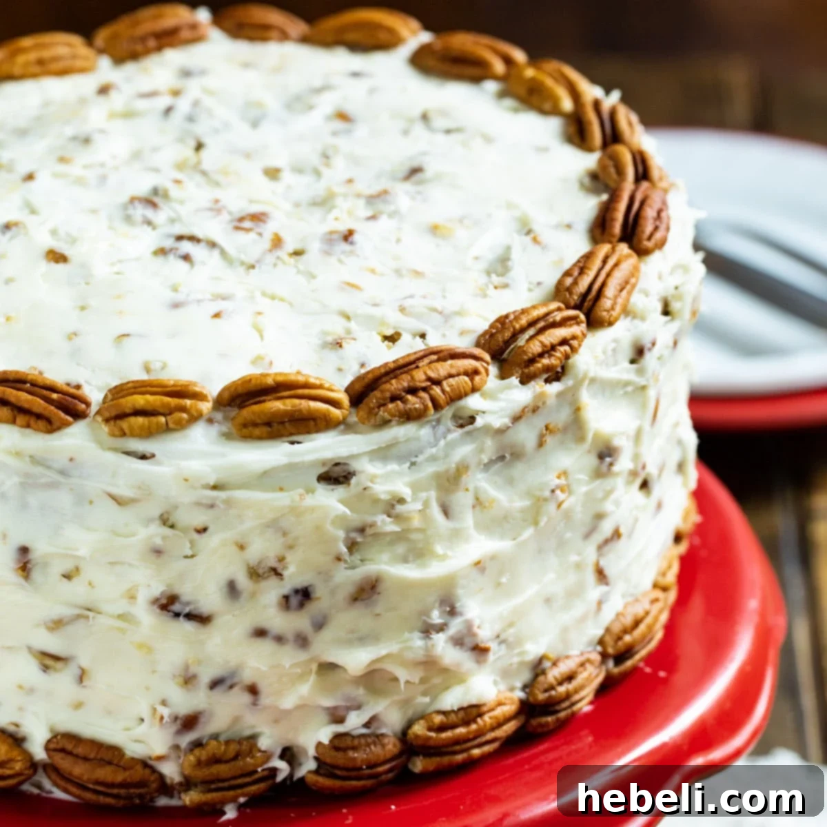 Exquisite Italian Cream Cake on a vibrant red cake stand, perfectly frosted with cream cheese, coconut, and pecans.