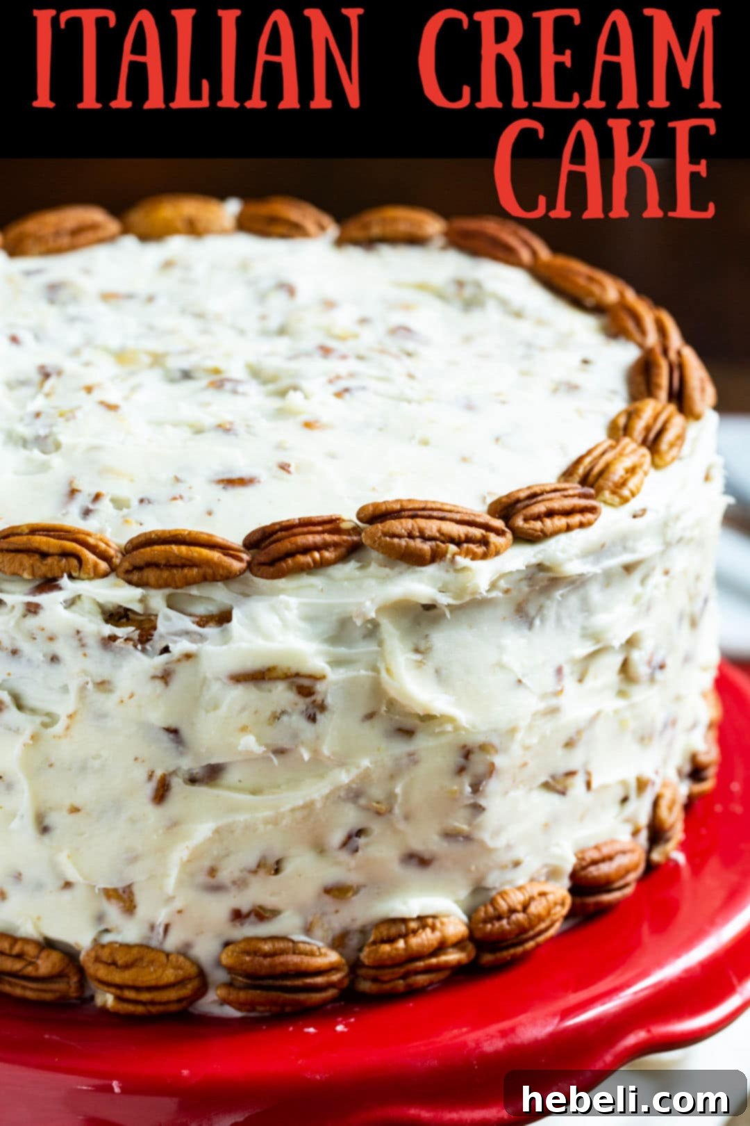 Three-layer Italian Cream Cake with cream cheese frosting, coconut, and pecans, presented on a vibrant red cake stand.