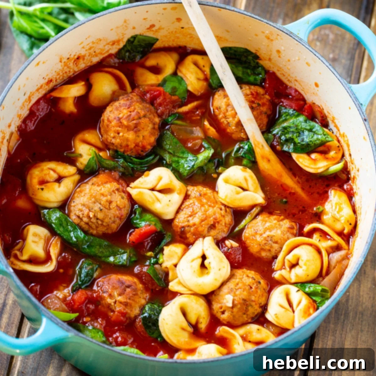 Hearty Meatball and Tortellini Soup simmering in a rustic Dutch oven.