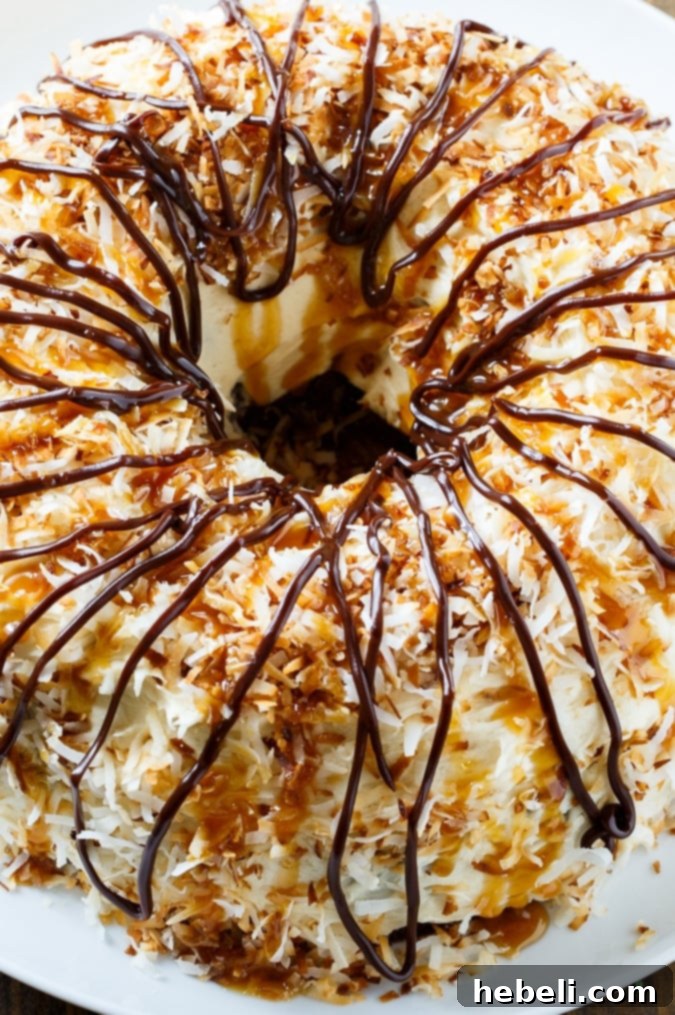 A slice of Samoa Bundt Cake showcasing its moist chocolate interior, caramel frosting, and toasted coconut topping.
