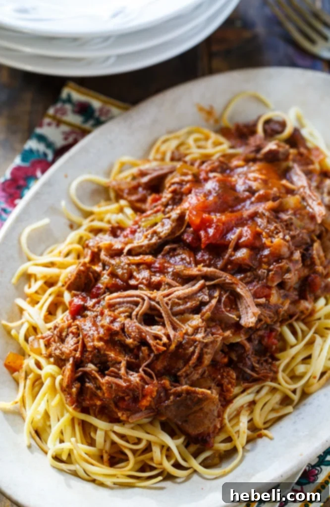 Close-up of Slow Cooker Short Rib Sauce simmering with fresh herbs on top