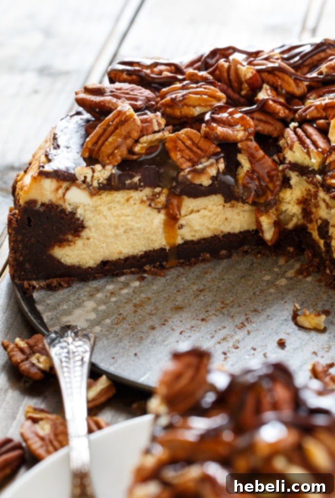 Brownie Bottom Turtle Cheesecake 6 A serving of Turtle Brownie Cheesecake ready to be enjoyed, showcasing the rich layers and generous toppings.