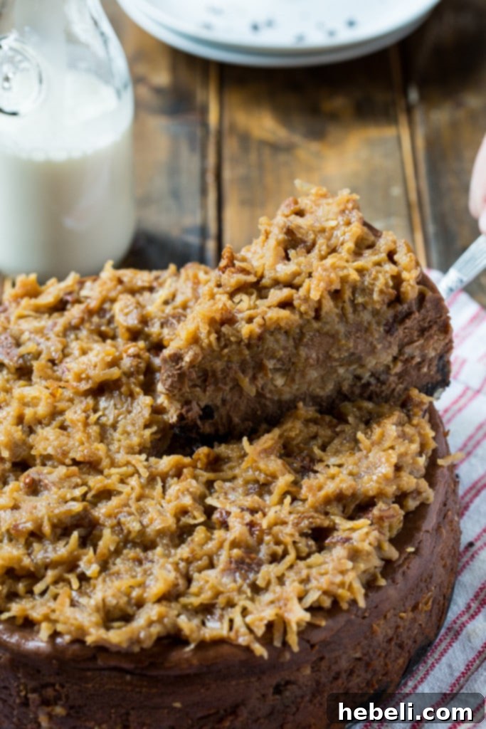 Slice of German Chocolate Cheesecake revealing the middle layer of coconut-pecan frosting.