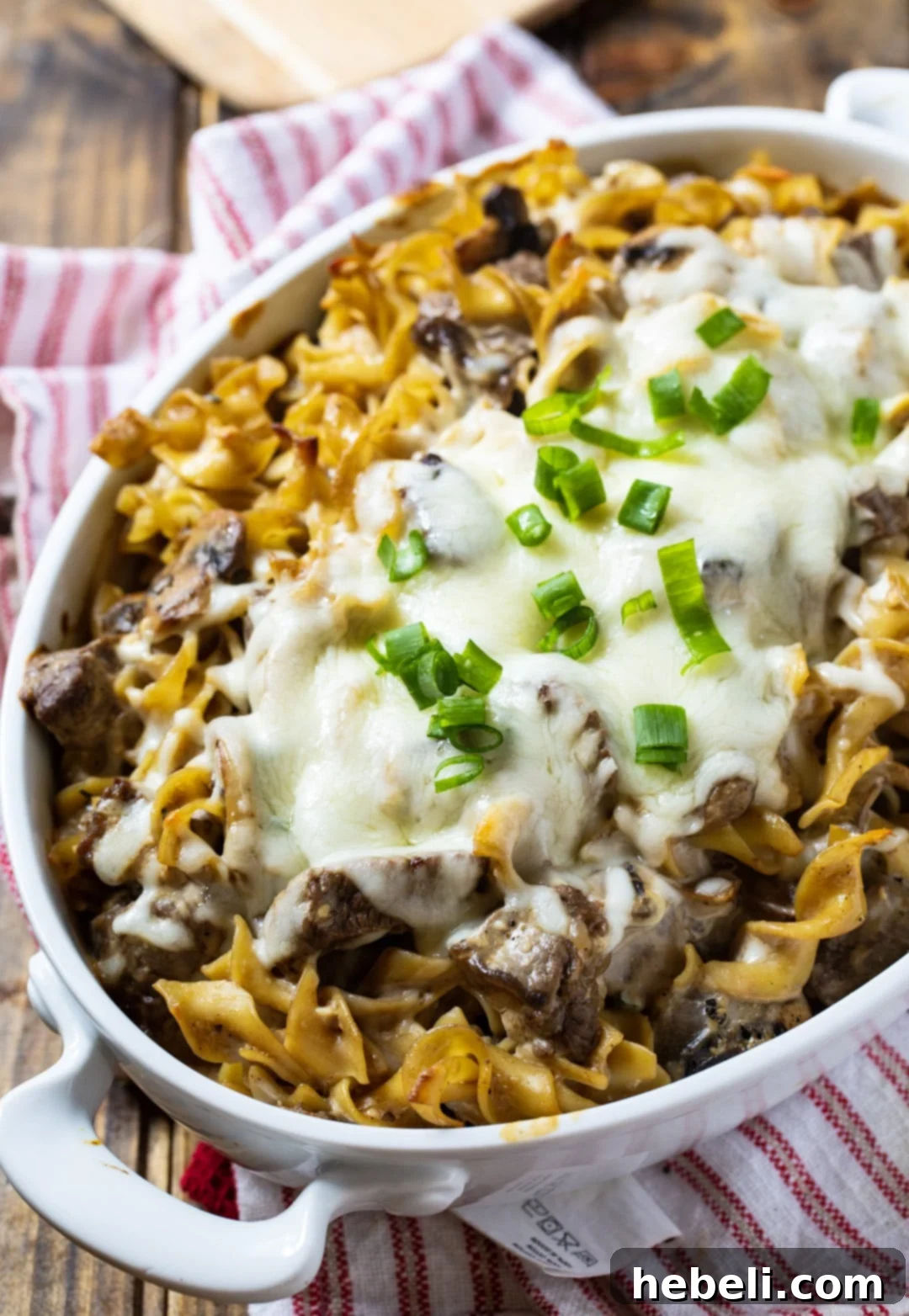 Close-up of Beef Stroganoff Casserole topped with golden melted cheese in a baking dish.