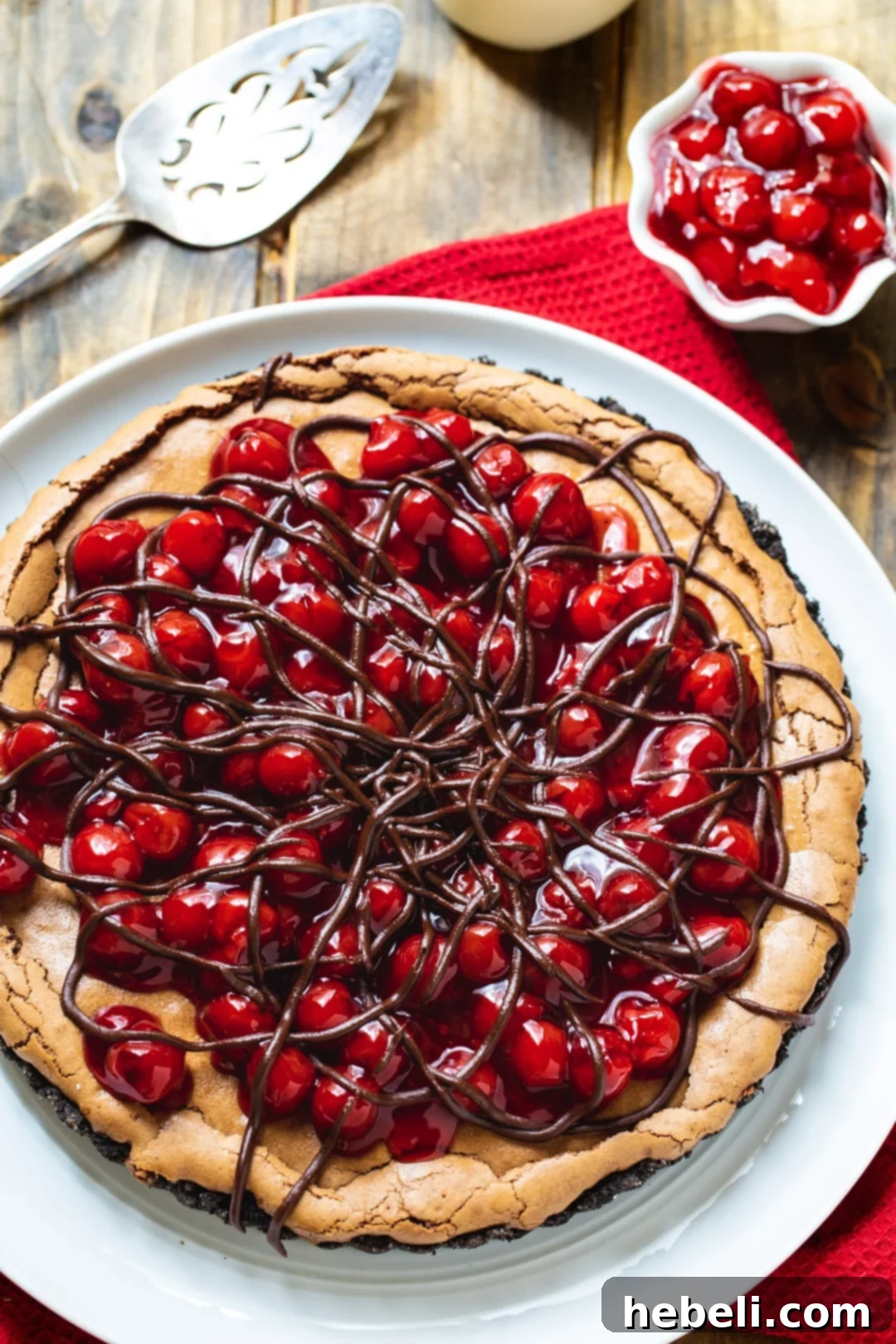 A slice of Black Forest Tart next to a bowl of fresh, glistening cherries.