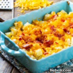 Close-up view of Cheesy Bacon Ranch Potatoes in a square dish, featuring a rich, golden-brown topping of melted cheese and crispy bacon.