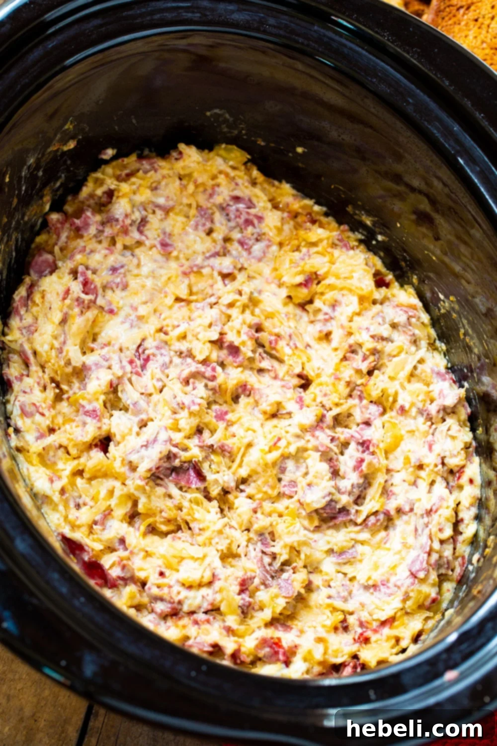 Reuben Dip in a black slow cooker.