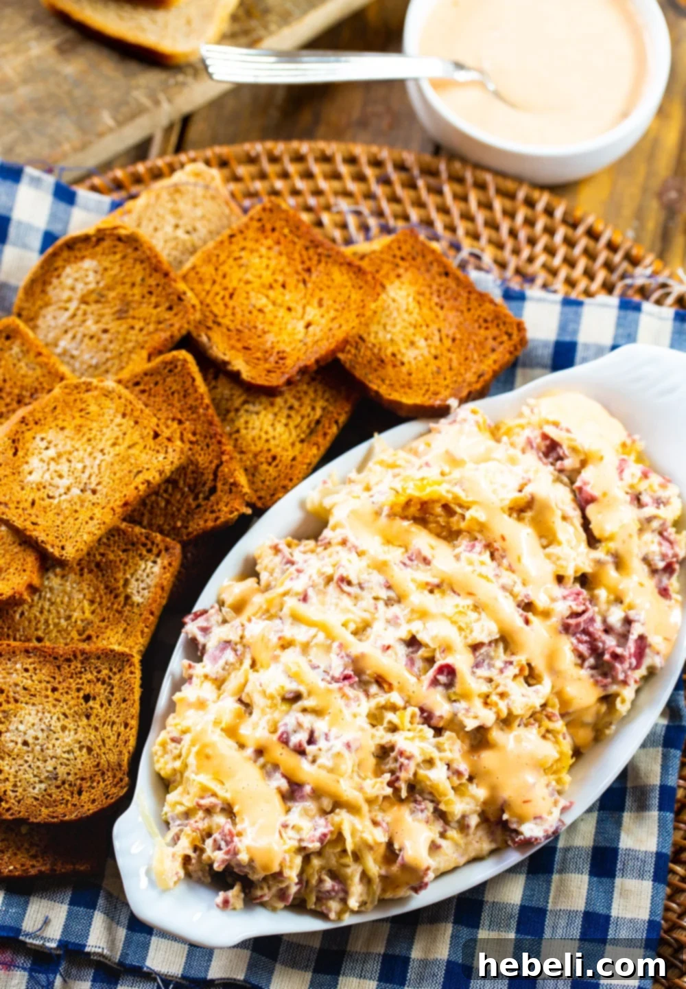 Slow Cooker Reuben Dip in a serving dish with toasted mini bread slices.