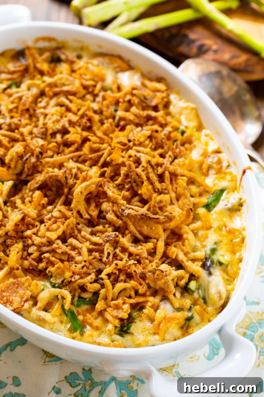 Finished Asparagus Casserole, golden brown and bubbly, in a ceramic baking dish.