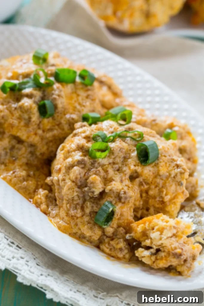 A stack of golden brown Sweet Potato Biscuits ready to be served with savory Chorizo Gravy