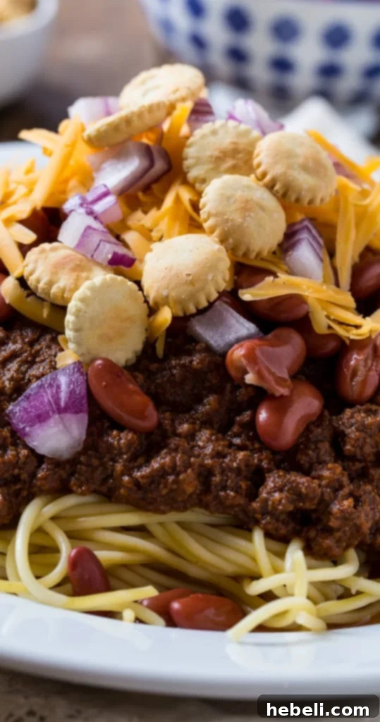 A bowl of Slow Cooker Cincinnati Chili with various toppings