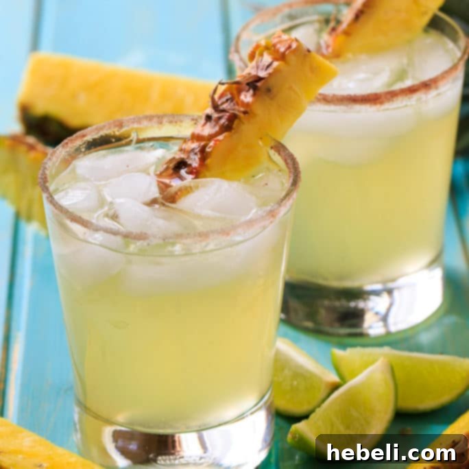 Pineapple-Cinnamon Margarita with pineapple wedge and cinnamon stick