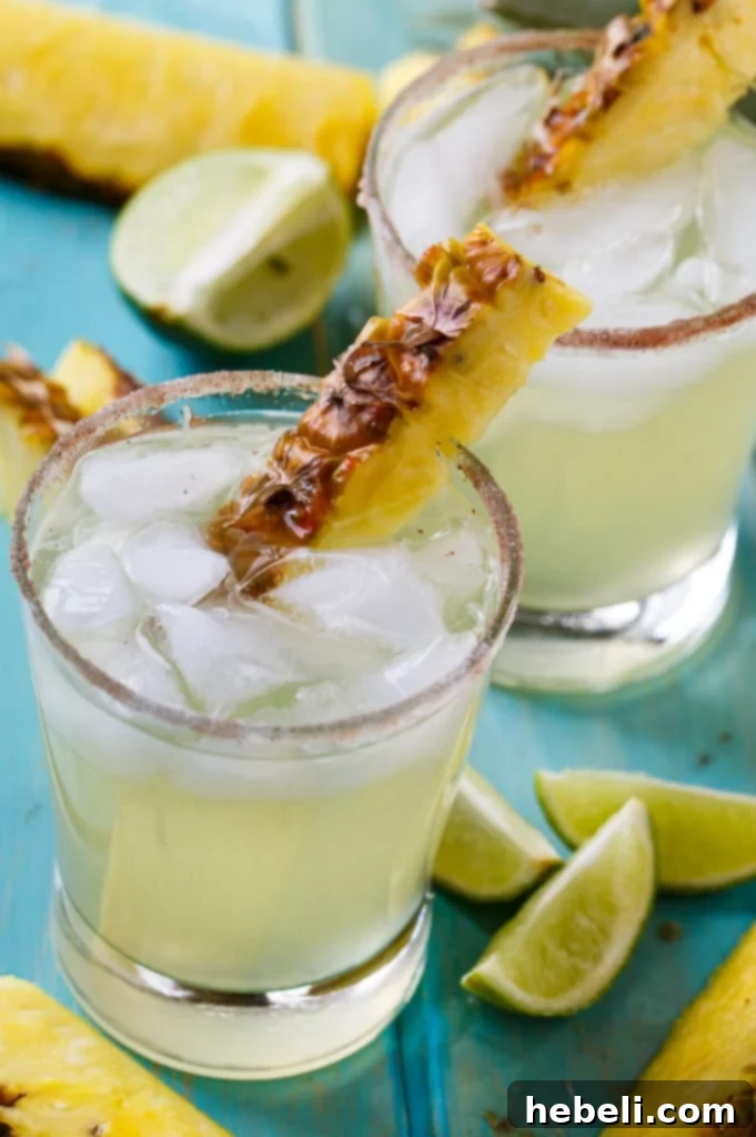 Pineapple-Cinnamon Margarita being poured into a glass with a prepared rim