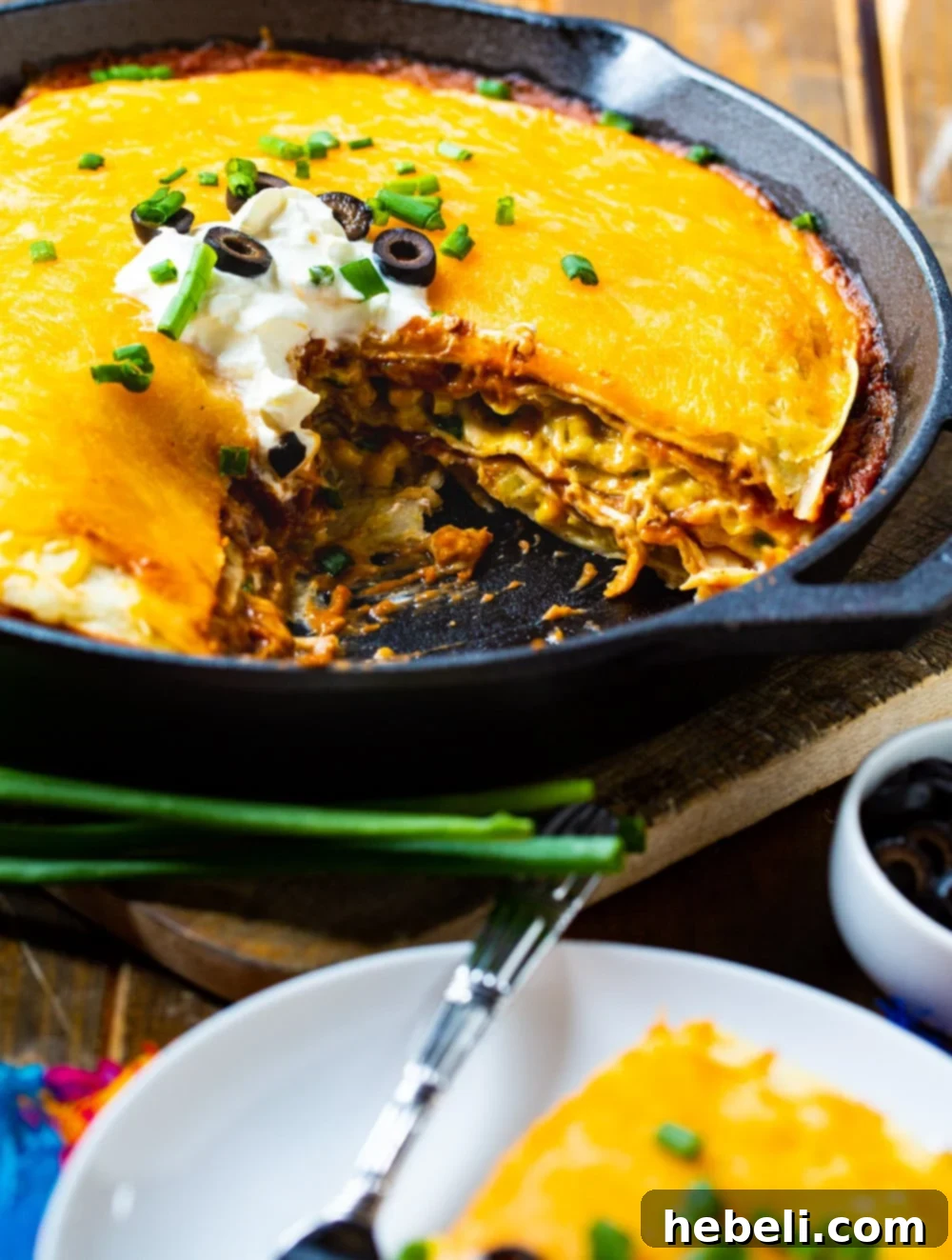 A slice removed from the One Pot Chicken Tortilla Pie in the cast iron pan, revealing the delightful layered interior.