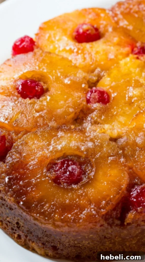 A close-up shot of a slice of Slow Cooker Pineapple Upside Down Cake, garnished with whipped cream