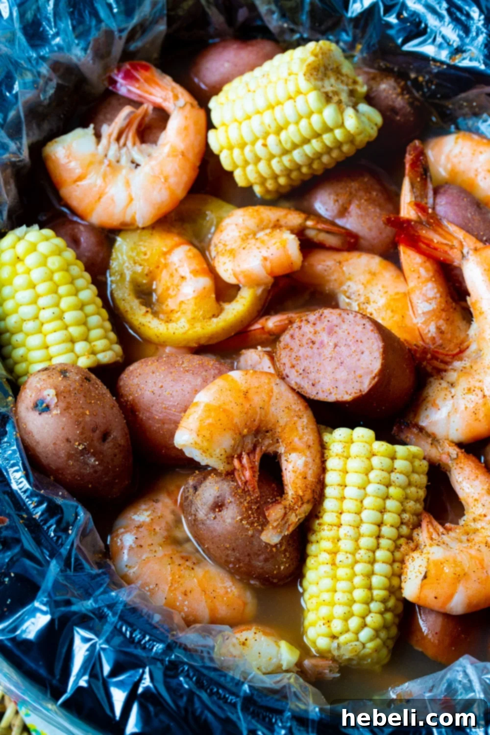 Crockpot Low Country Feast 3 A slow cooker filled with the initial layers of Low Country Boil ingredients, including potatoes, lemon, and seasonings.
