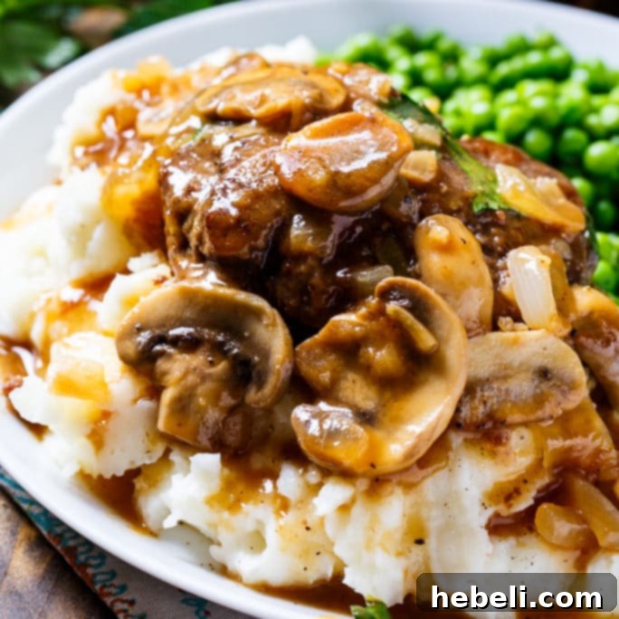 Salisbury Steak served with mashed potatoes and covered in a rich mushroom gravy