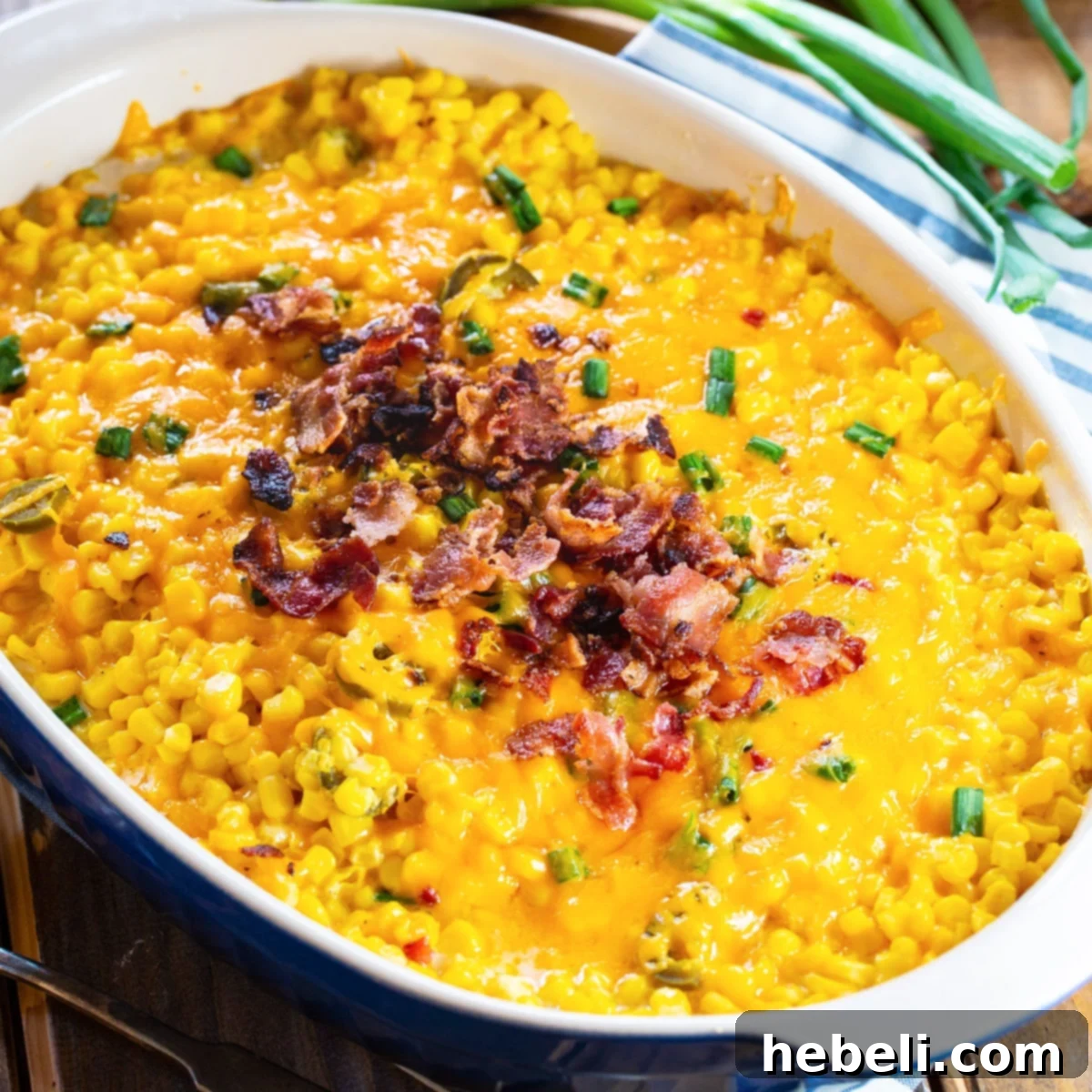 Cheddar Corn Casserole topped with bacon in casserole dish. A perfect holiday side dish.