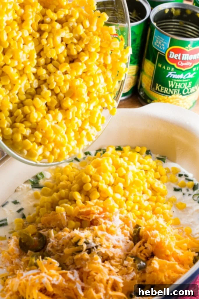 Cheddar Corn Casserole with lots of cheese and bacon, ready to be scooped.