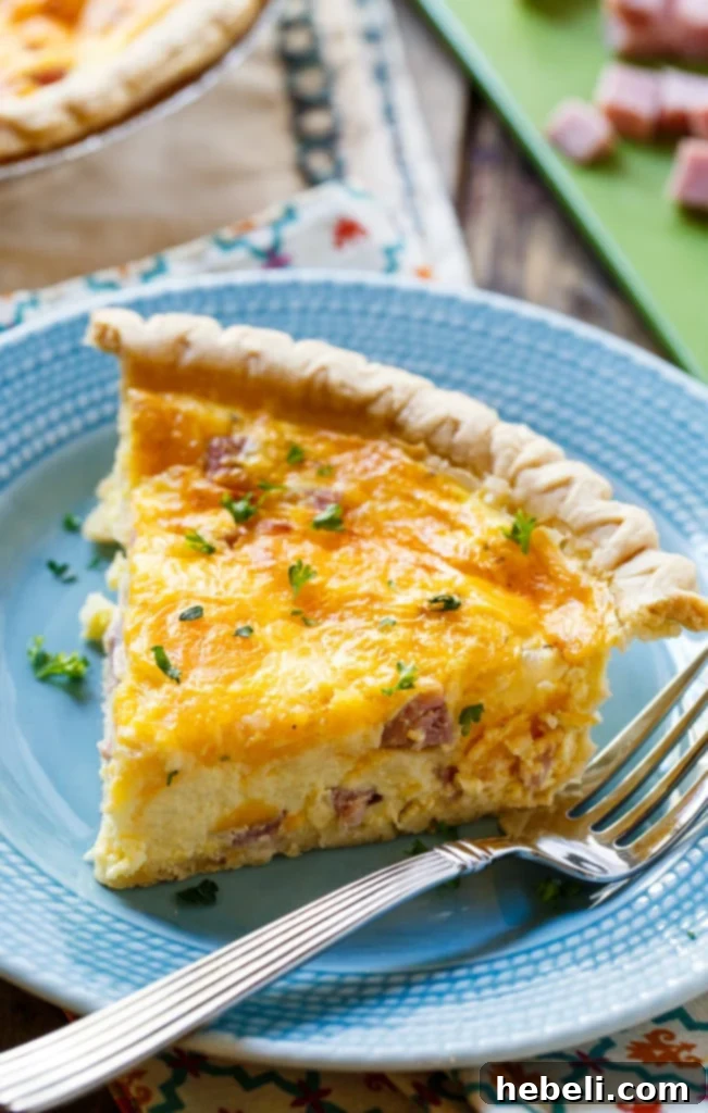 Close-up of a slice of Easy Ham and Cheese Quiche, showcasing the ham and cheese filling