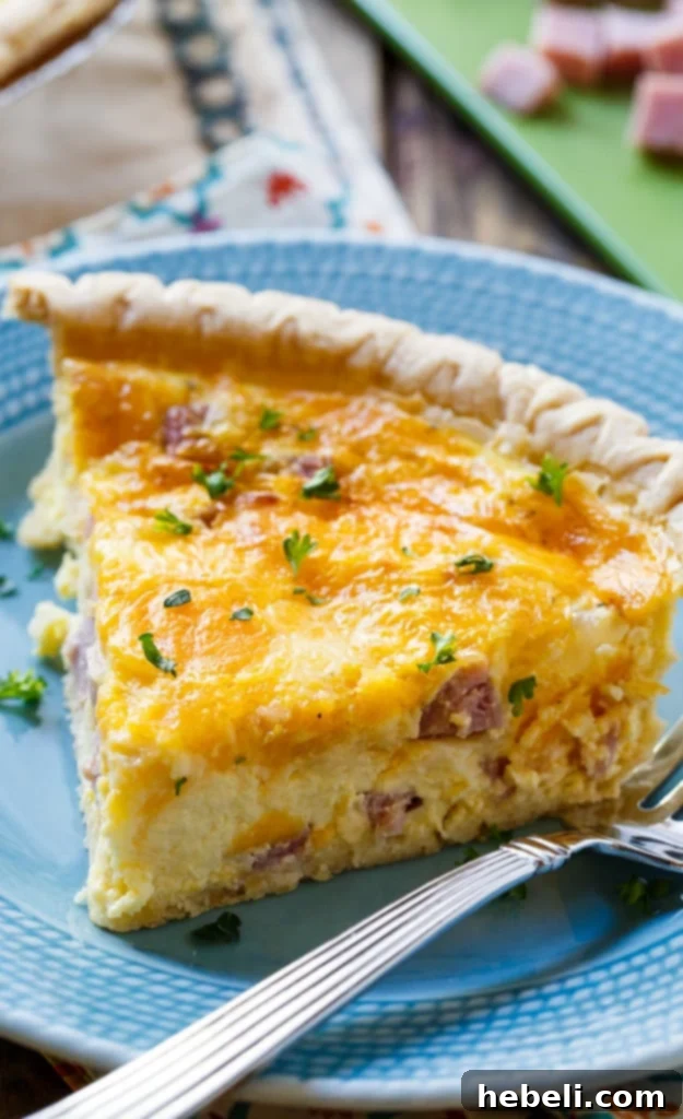 Assembling the Easy Ham and Cheese Quiche in a pie crust before baking