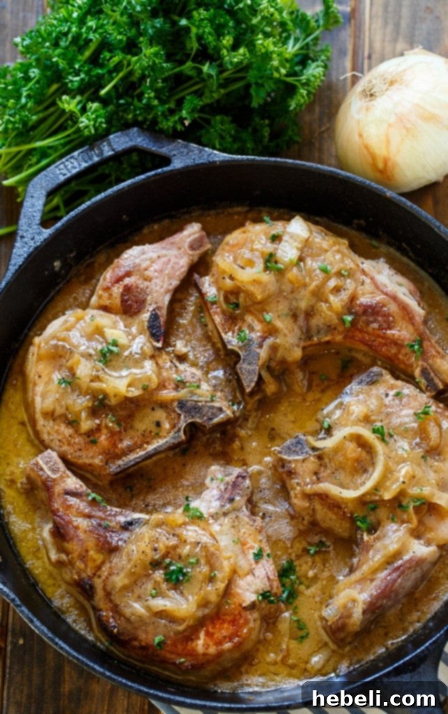 Southern-Style Smothered Pork Chops in an easy onion gravy, simmering gently.