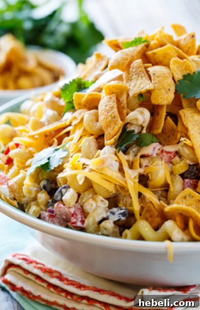 Zesty BBQ Ranch Pasta Toss 7 A beautiful, high-angle shot of the BBQ Ranch Pasta Salad in a large serving bowl, topped with crispy corn chips and fresh cilantro, set against a rustic background.