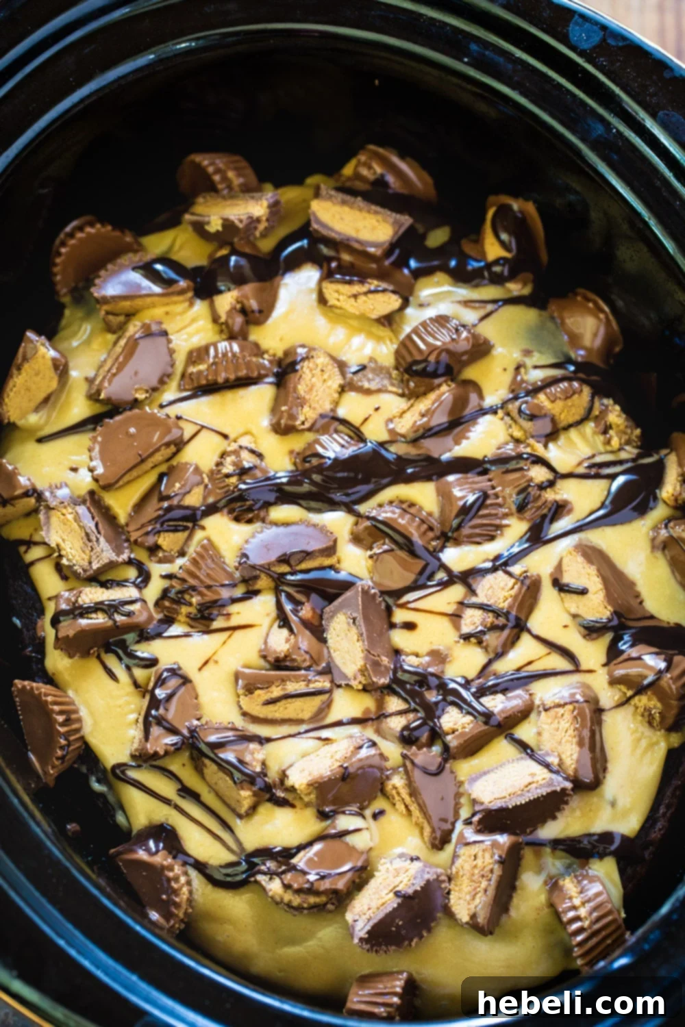 Close-up of Slow Cooker Chocolate Peanut Butter Cake topped with a generous amount of chopped peanut butter cups.